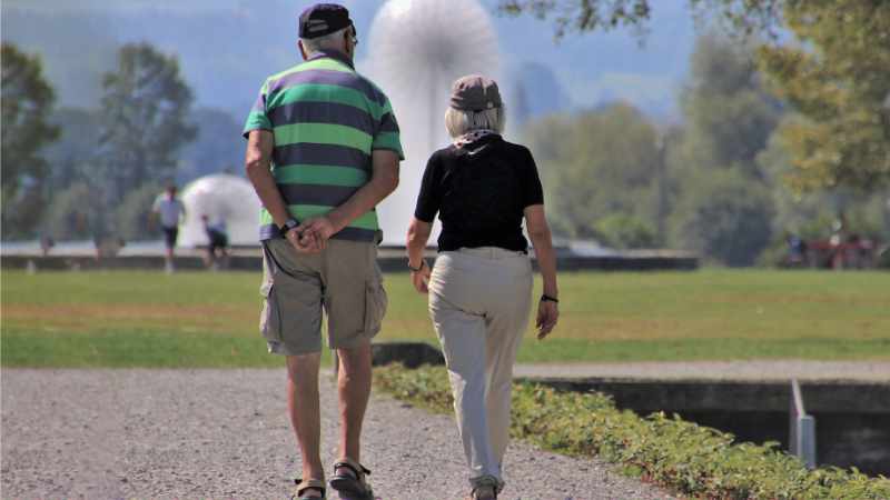 Senior couple taking a walk in the park, senior foot care.