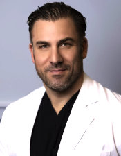 Dr. Gabriel Gambardella, podiatrist wearing white medical coat, smiling.