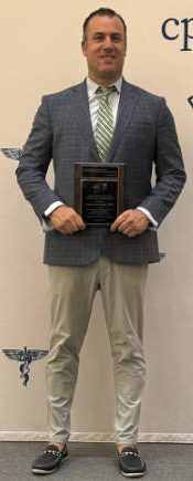 Dr. Gabriel Gambardella holding John Walker 2025 Podiatrist of the Year Award.